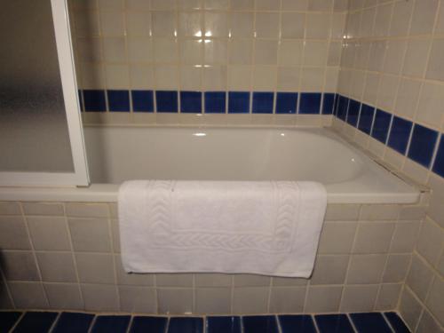圣保罗-德旺斯Le Mas des Gardettes的白色浴缸,上面有白色毛巾