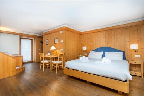 瓦尔布鲁纳Valbruna Inn Bed & Breakfast的卧室配有一张床和一张桌子及椅子