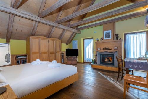 瓦尔布鲁纳Valbruna Inn Bed & Breakfast的一间卧室设有一张大床和一个壁炉