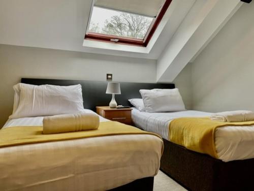 庞蒂兰The Diamond Inn的一间卧室设有两张床和天窗