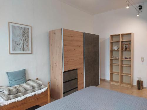KluisChalet Heiderose SPA - Kamin, Sauna & Wellness的一间卧室配有一张床、一个橱柜和一把椅子