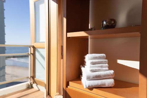 埃斯波森迪Ofir Beach Flat的一堆毛巾放在窗边的架子上