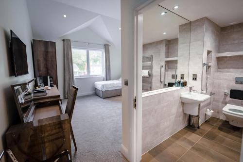 LaxeyShore Hotel Laxey的浴室配有盥洗盆、卫生间和浴缸。