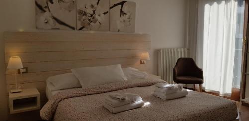 平佐洛加尼圣洛伦索酒店的一间卧室配有一张床,上面有两条毛巾
