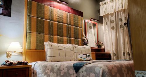 Kampong Bukit KatilFaridah Homestay Melaka Muslim Friendly的一间卧室配有一张带大型木制床头板的床