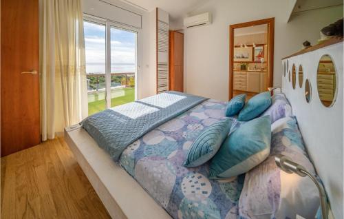 马尔格莱特德玛Lovely Home In Malgrat De Mar With Swimming Pool的卧室配有带枕头的大床和窗户。