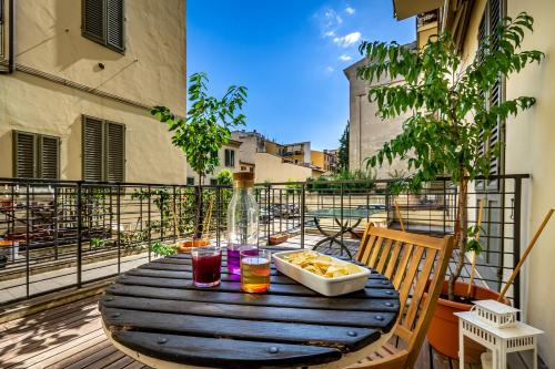 佛罗伦萨Luxury apt in the heart of city out of ZTL的阳台上的木桌和一碗食物