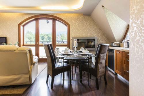 扎科帕内Apartament De Lux Cicha Woda的带桌椅的厨房和带窗户的厨房