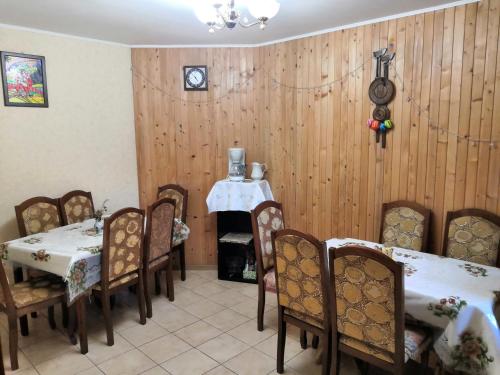 亚列姆切Oskolok Dovbusha Mini-Hotel的一间设有桌椅的用餐室和墙上的时钟