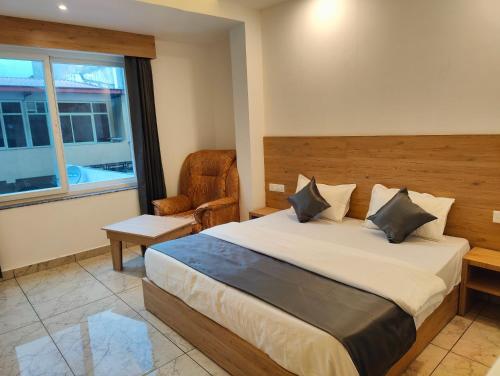 瑞诗凯诗Sonu Guesthouse & Hostel的卧室配有床、椅子和窗户。