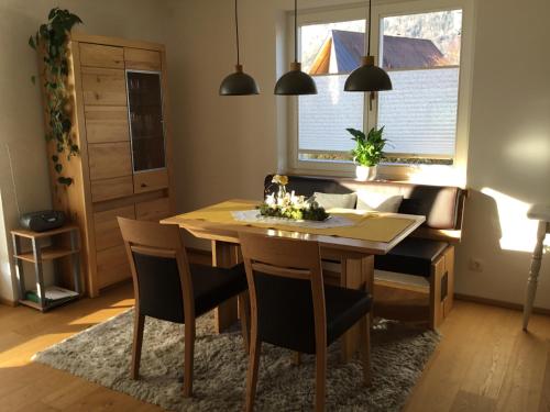 萨尔察赫河畔戈灵Ferienwohnung Neureiter的一间带木桌和椅子的用餐室