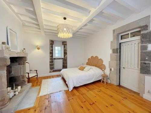 勒布伊Logis du Chandelier的一间白色卧室,配有一张床和一个壁炉