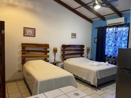 卡里略Cabinas El Colibri的蓝色墙壁客房的两张床