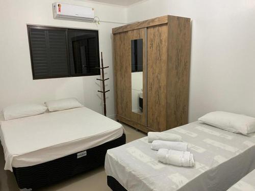伊茹伊Apart-Hotel Ijuí的一间卧室设有两张床和木制橱柜