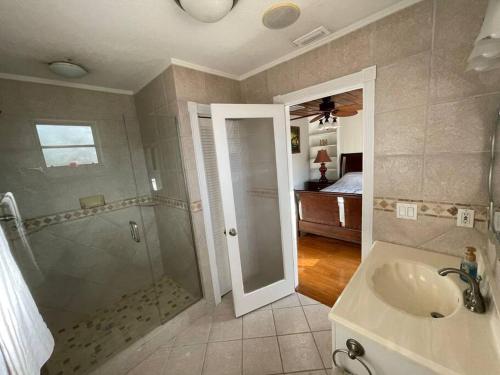 圣彼得堡The perfect Gulfport Fl Getaway!的一间带水槽和淋浴的浴室以及一张床