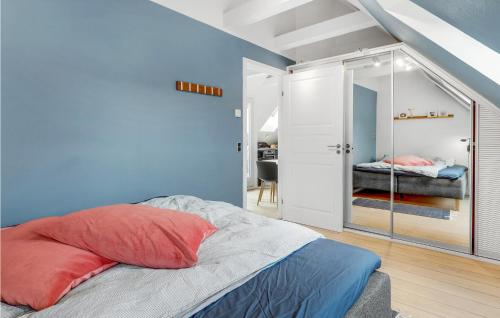 斯瓦讷克Beautiful Apartment In Svaneke With 2 Bedrooms And Wifi的一间拥有蓝色墙壁的卧室和一张带镜子的床