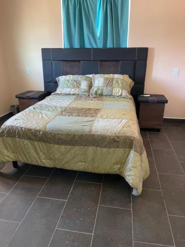 佩尼亚斯科港Condominio puerto peñasco的一间卧室配有一张带2个床头柜的大床