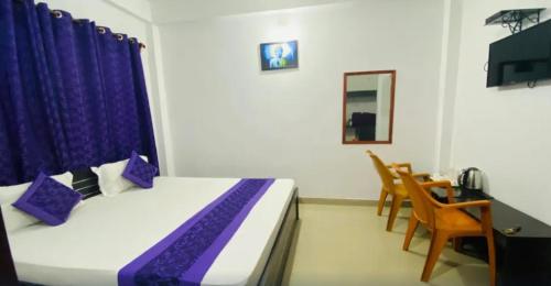 巴加Ocean Glass的一间卧室配有一张带紫色枕头的床和一张桌子