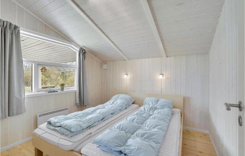 AskebyStunning Home In Askeby With Sauna的一间设有三张床的房间,设有窗户
