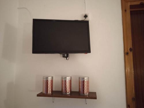 圣乔治斯Villa Kaloudis Rooms的墙上的平板电视,有三个金属罐子