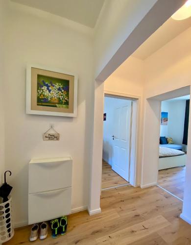 科布伦茨PnT home-stilvolles Apartment的一间设有走廊、一张床和墙上一幅画的房间
