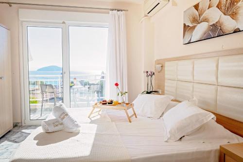 伊拉克里萨Vournelis Beach Hotel and Spa的一间卧室设有一张大床和大窗户