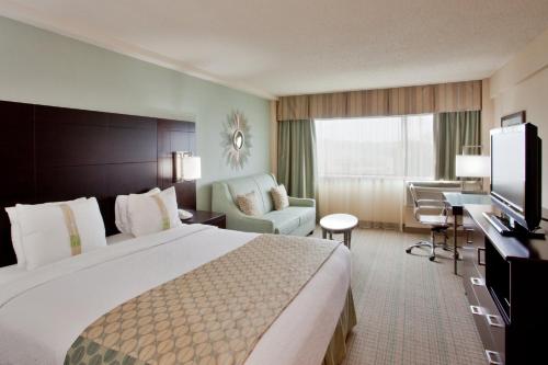 弗吉尼亚海滩弗吉尼亚海滩-诺福克假日酒店的酒店客房设有一张大床和一张书桌。