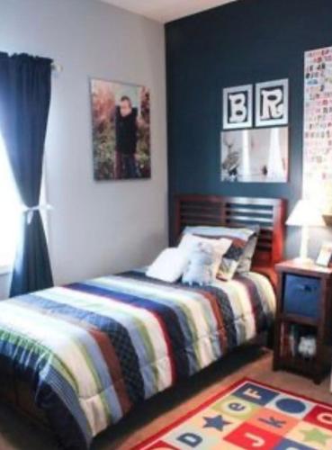 利物浦Home away from Home的一间卧室配有一张带条纹毯子和桌子的床