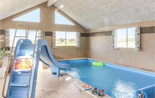 斯泰厄Gorgeous Home In Stege With Sauna的一个带滑梯的室内游泳池和一个游泳池