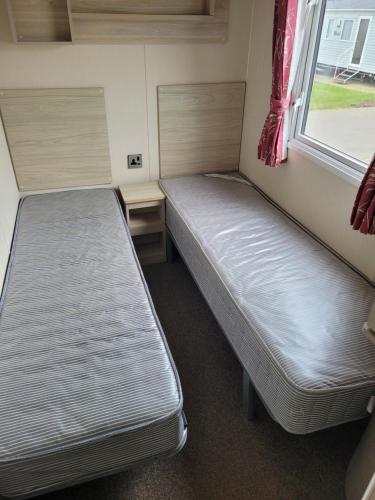 Saint OsythSeawick Holiday Park的小型客房 - 带2张床和窗户