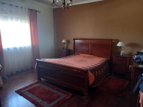 奥比多斯Casa da Avó Judite的一间卧室设有一张木床和一个窗户。