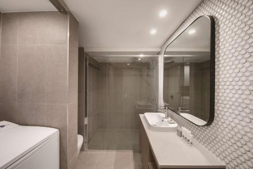 悉尼悉尼库吉海阿迪纳公寓式酒店的一间带水槽、淋浴和镜子的浴室