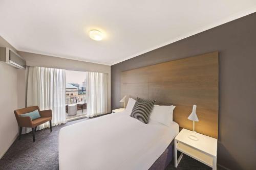 悉尼悉尼萨利山阿迪纳公寓酒店 的配有一张床和一把椅子的酒店客房