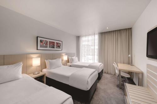 墨尔本墨尔本港区旅程住宿酒店的酒店客房配有两张床和一张书桌