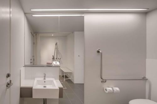 墨尔本墨尔本港区旅程住宿酒店的一间带水槽、卫生间和镜子的浴室