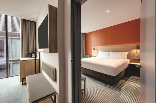 悉尼Travelodge Hotel Hurstville Sydney的一间酒店客房,配有一张床和一台电视