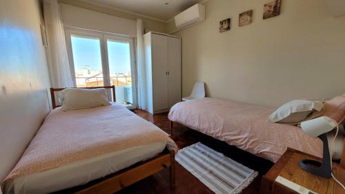奥埃拉斯Oeiras Historic Bedrooms的一间小卧室,配有两张床和窗户