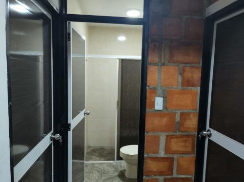 RozoVILLA BRAULIO的一间带卫生间和砖墙的浴室