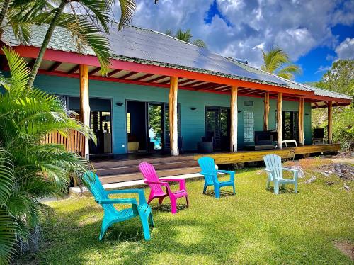 莫雷阿Turia's Beach Villa的一组椅子坐在房子外面