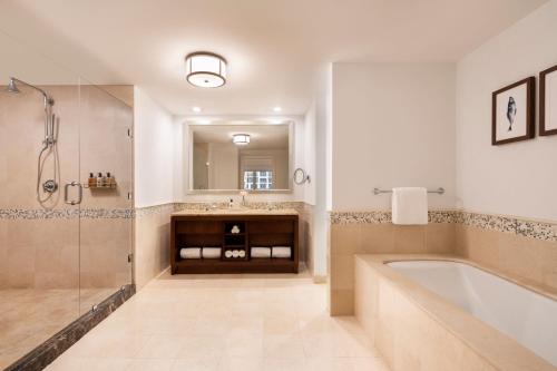 棕榈滩丽思卡尔顿阿鲁巴酒店的带浴缸、水槽和镜子的浴室