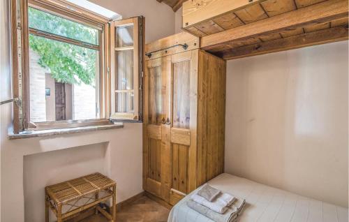 Ostra VetereCasa Panorama的一间卧室设有木制橱柜和窗户。