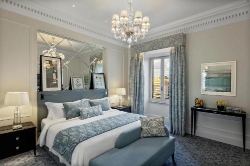 罗马圣雷吉斯罗马酒店的一间卧室配有一张大床和一个吊灯。