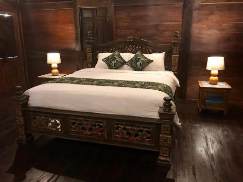 塔巴南Alas Arum Ecolodge的一间卧室配有一张大床和两盏灯
