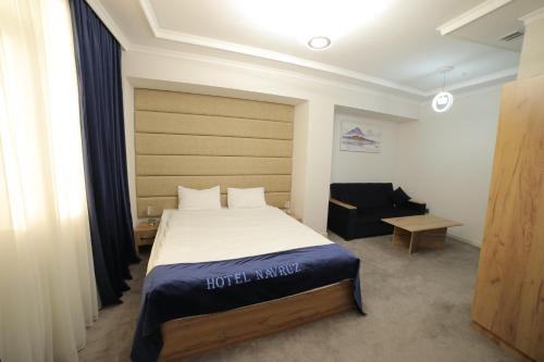 乌尔根奇HOTEL NAVRUZ的配有一张床和一把椅子的酒店客房
