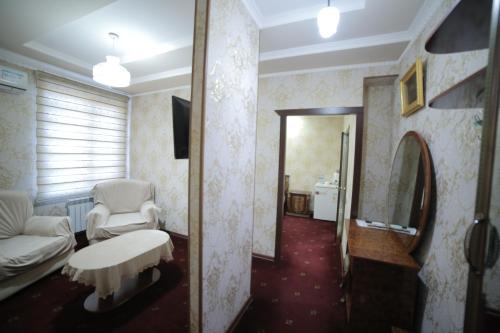 乌尔根奇HOTEL NAVRUZ的带沙发、桌子和镜子的客厅