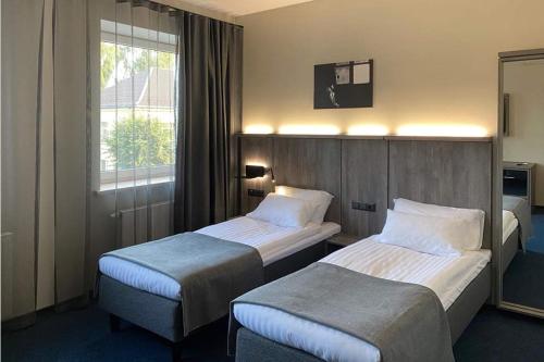 扎拉赛Brut Wine Hotel的酒店客房设有两张床和窗户。