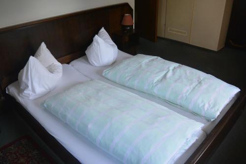 Burgstaedt诺曼斯餐厅及酒店的一张带白色床单和枕头的床