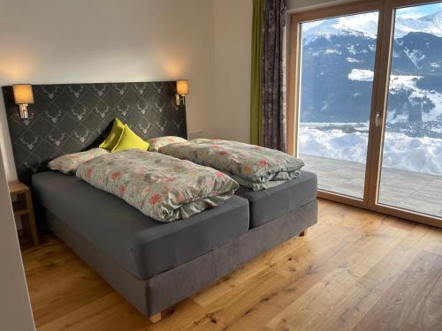 米特西尔Ferienwohnung Traumblick -Familie Seber的一间卧室设有一张床和一个大窗户