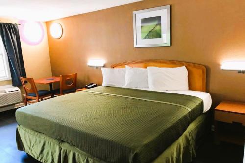 塔拉哈西OYO Hotel Tallahassee Downtown的酒店客房设有一张大床和一张桌子。
