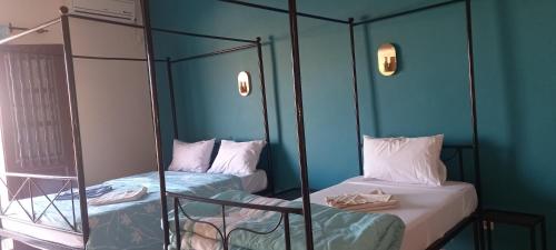 圣路易斯HÔTEL ETOILE DU SUD的蓝色墙壁的客房内设有两张双层床。